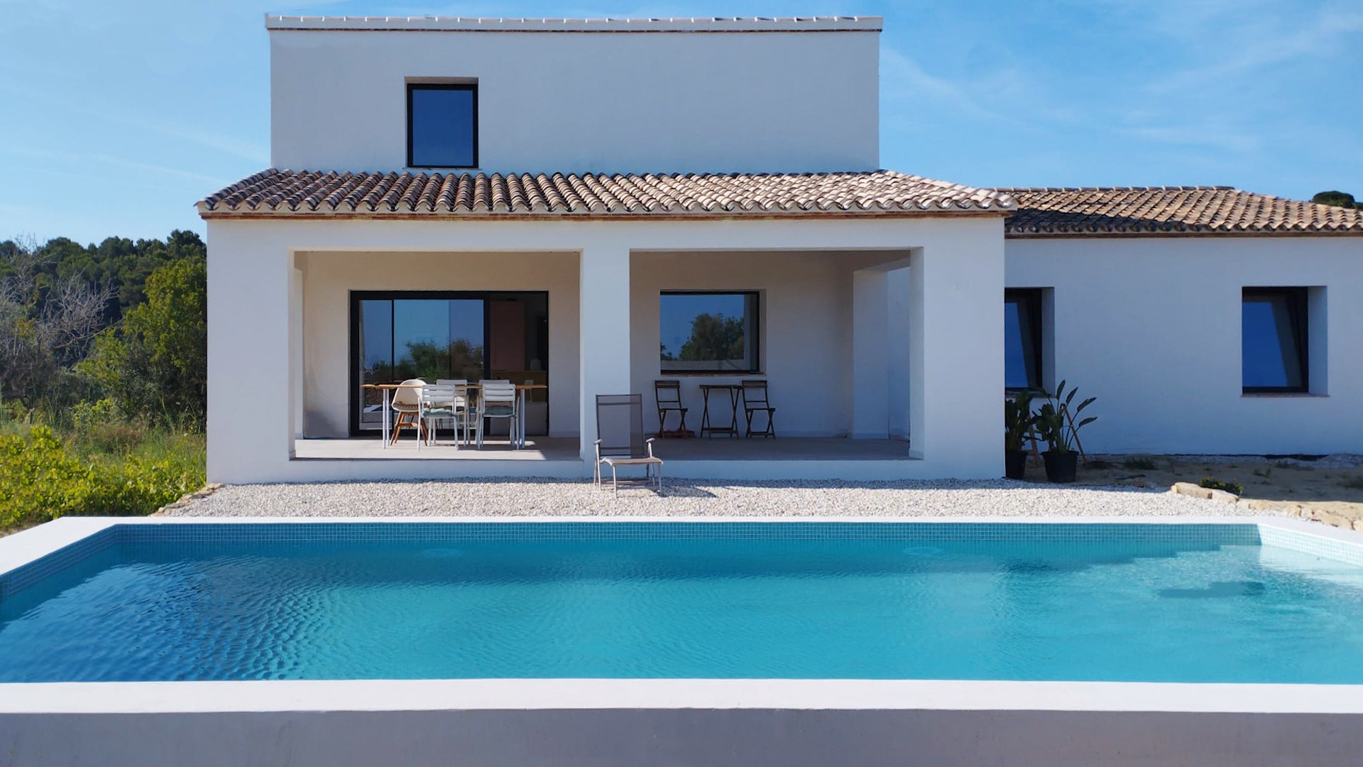 Fachada posterior de una vivienda nueva con piscina en Benissa decorada por decoralinks